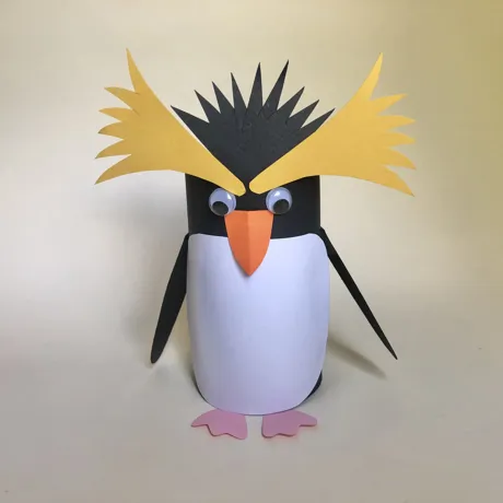 How to Create a Penguin Step 6: Finally, glue the yellow top feather shapes and black feather shape to the penguin.